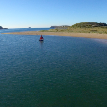 Aerial view of sail boat by Rock Beach