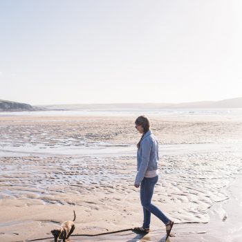 Dog walker on Polzeath Beach