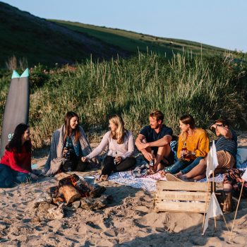 Group enjoying a sundowner on Polzeath Beach