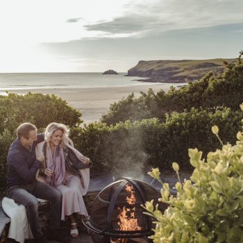 Couple beside the firepit at Carn Mar in Polzeath