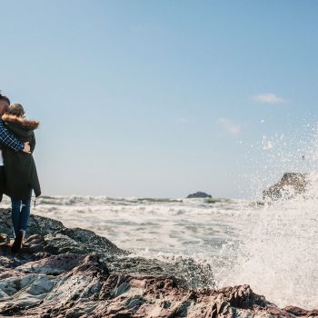 Couple watching the waves at Polzeath Beach